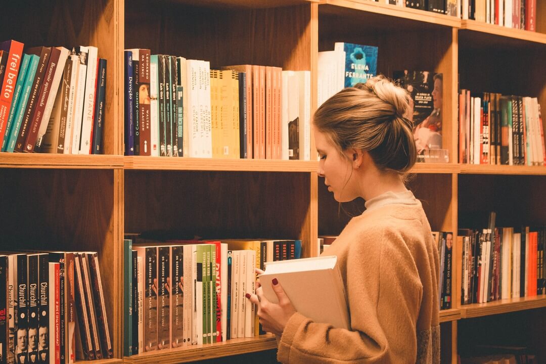 Oxford Scholastica English student browsing books in a library.