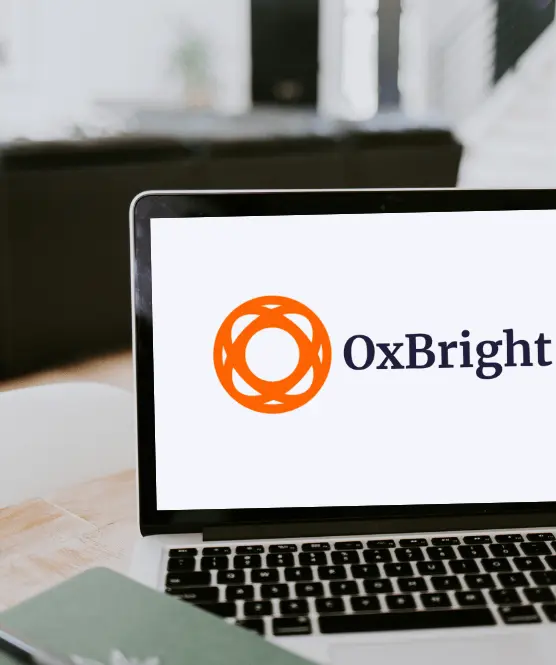 Photo of a laptop displaying the OxBright logo