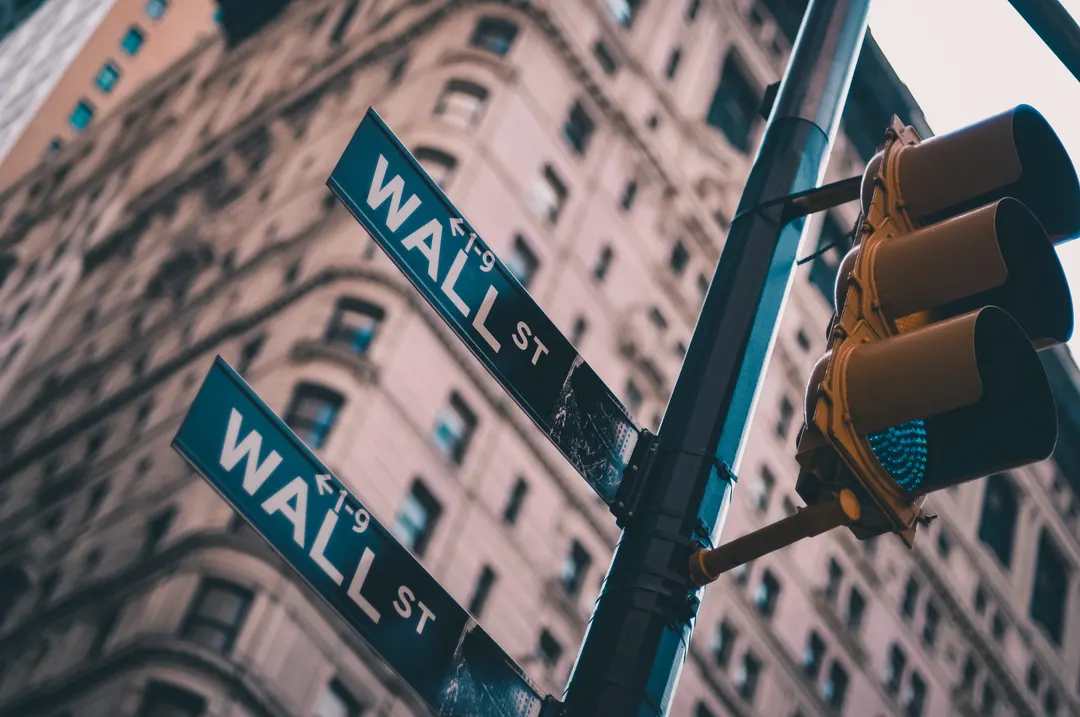 A street sign pointing towards Wall Street, New York City.