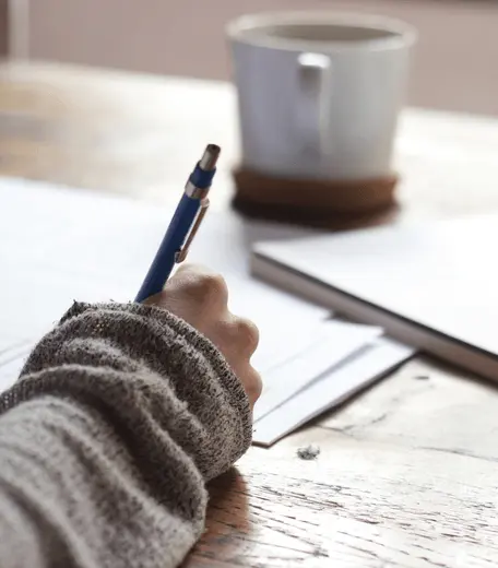 Close up of a hand writing in a notebook