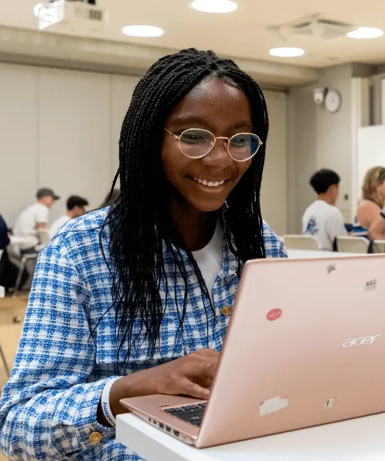 OxBright student smiling while working on laptop