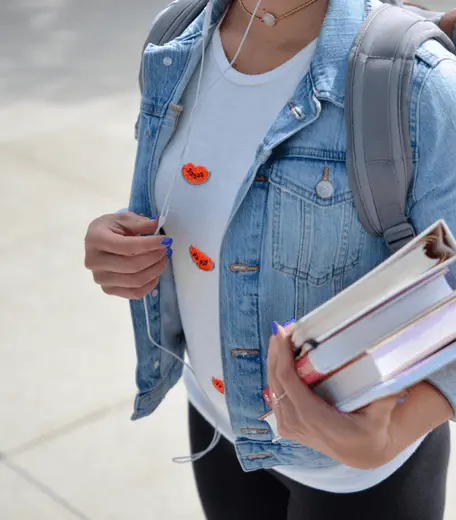 Business student carrying a pile of books and folders