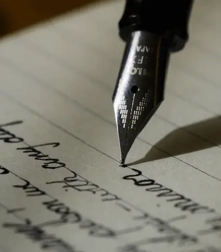 close up of fountain pen writing on lined paper