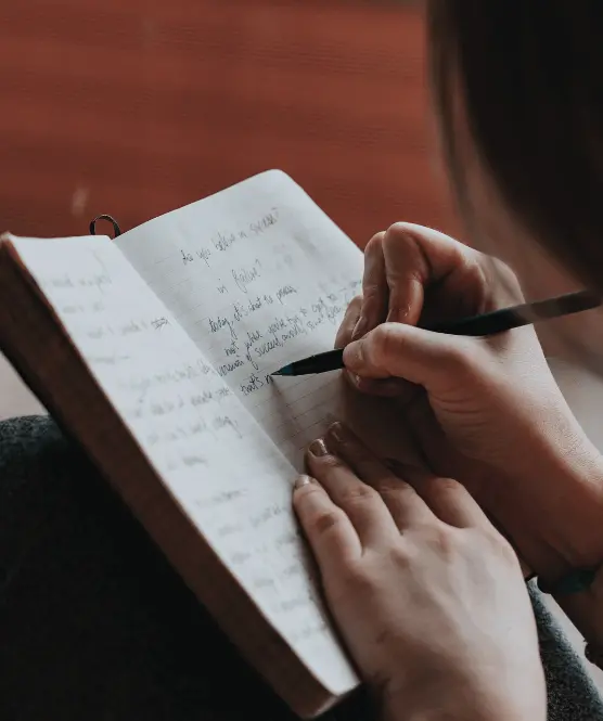 OxBright student writing in a notebook