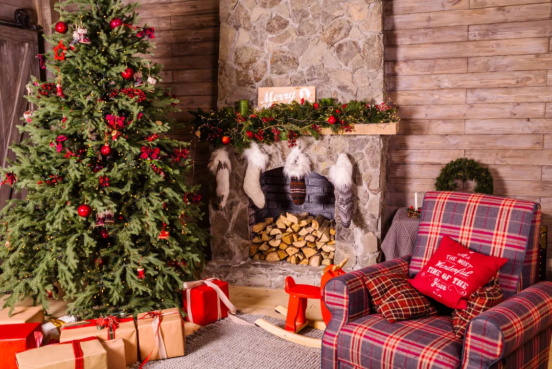 A living room decorated for Christmas, with a tree, presents and stockings