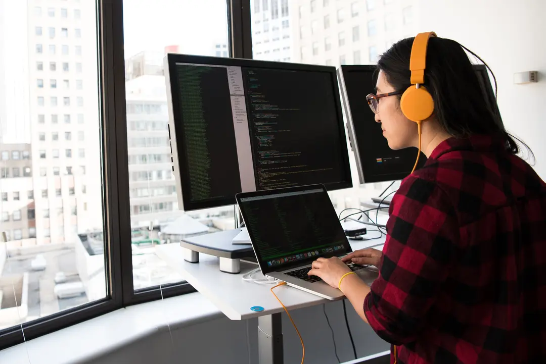 Person sitting at computer, coding