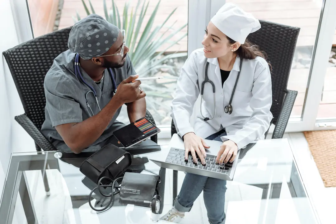 Two medical professionals sitting at a table talking