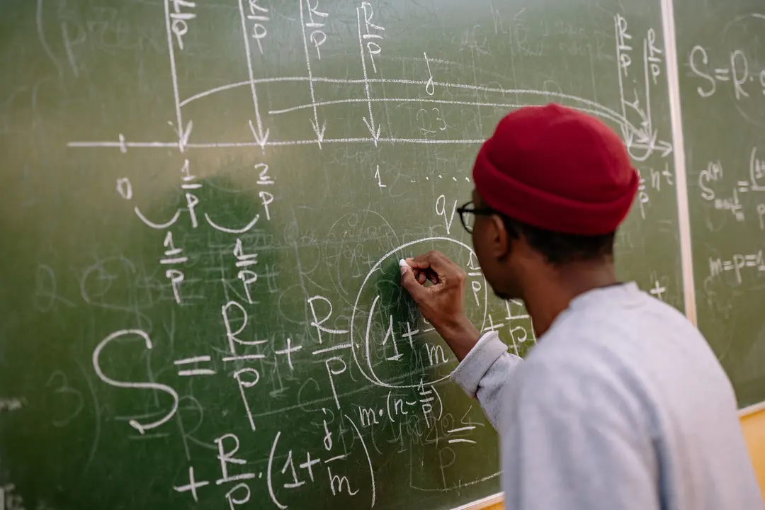 Person calculating mathematical equations on a chalkboard