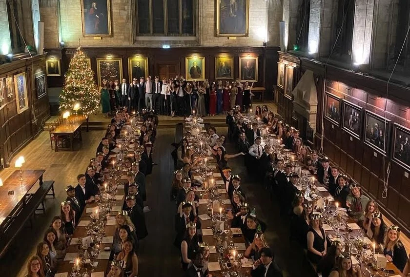 Oxford University students at a formal dinner, sitting at tables