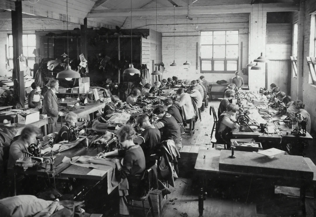 Group of people working in a factory during the Industrial Revolution