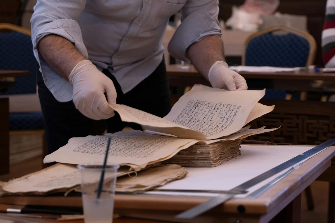 Person carefully handling a manuscript