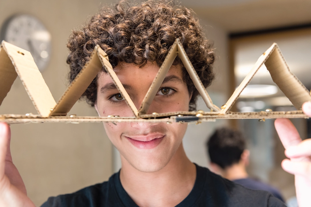 Student showing a cardboard model to the camera
